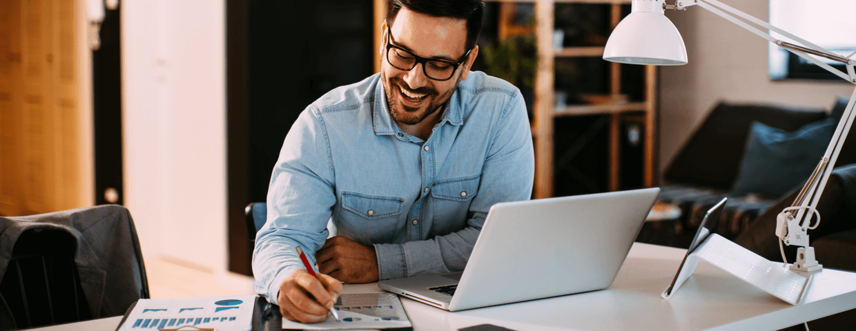 Young business man working at home with laptop and papers on desk