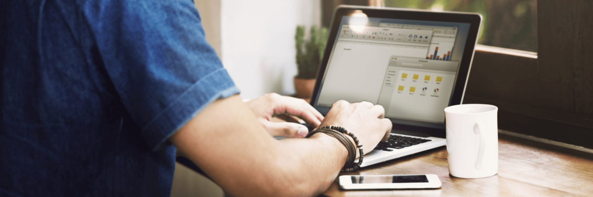 Male employee working remotely on laptop with documents, document management concept for remote employees or hybrid workforce, DMS