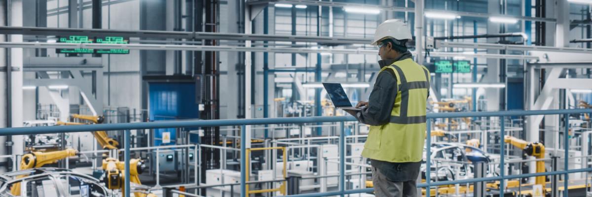 engineer holding a laptop in manufacturing plant