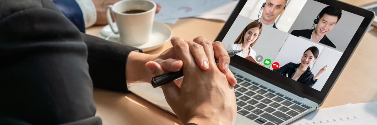 employee on virtual call surrounded by printed materials at home