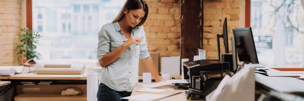 woman in office waiting for printer to finish 