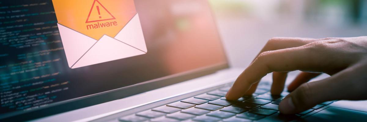 malware icon on a laptop screen, hand touching keyboard